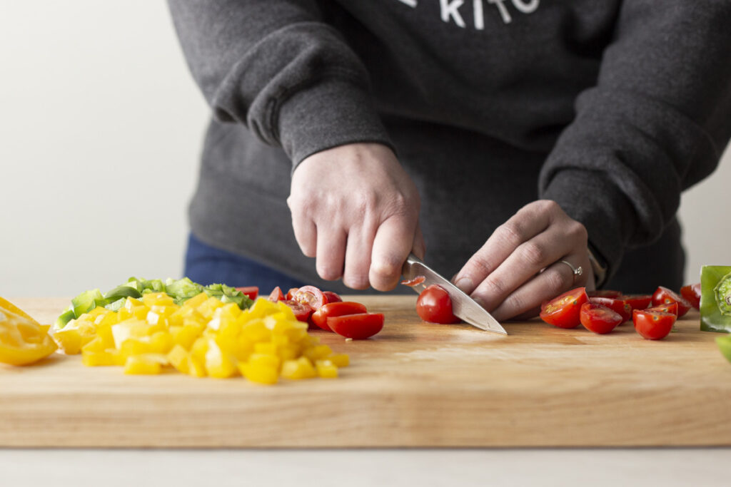 cutting peppers on a wood cutting board