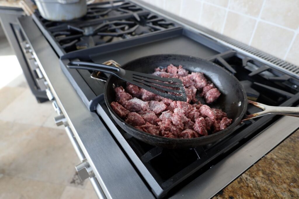 raw ground lamb in a frying pan