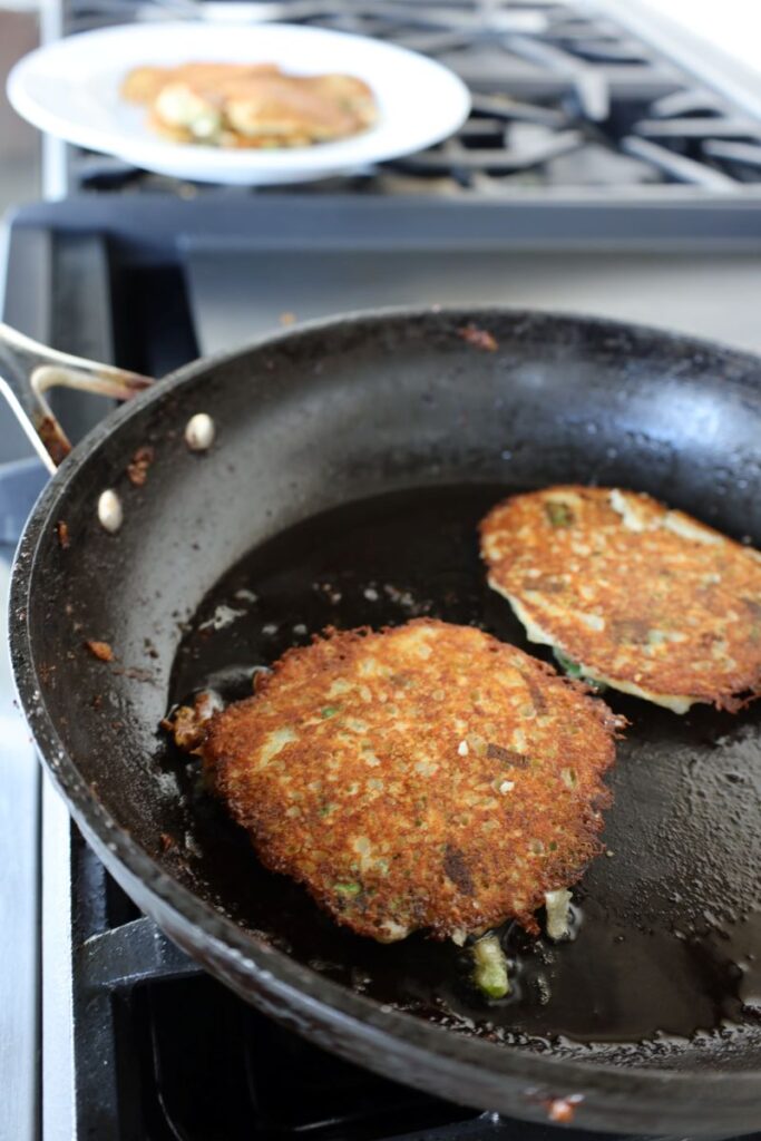 two golden brown Irish boxty in a frying pan