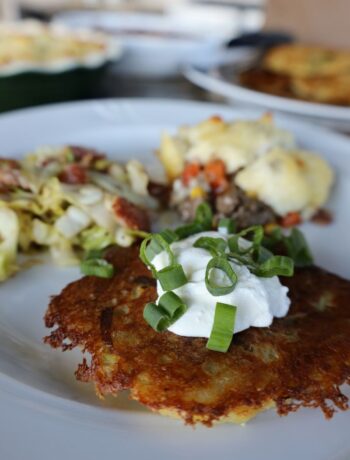 Irish Boxty on a white plate with shepherds pie and cabbage